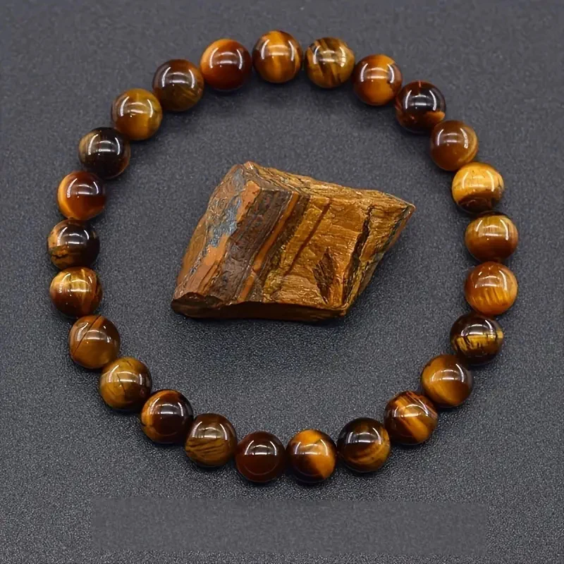 polished tiger eye bracelet beside natural tiger eye rough stone
