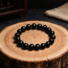 AI concept image: black obsidian bracelet on a wood slice